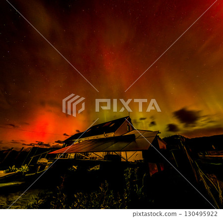 The Aurora Borealis, the northern lights, showing up above bungalow in County Donegal, Ireland 130495922
