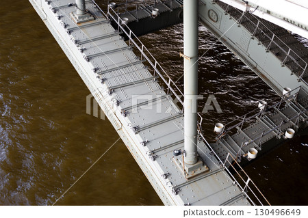 Close up of bridge metallic structure, focusing on robust connections and reinforced beams, emphasizing strength and durability of the bridge design that supports infrastructure Close up of bridge metallic structure, focusing on robust connections and reinforced beams, emphasizing strength and durability of the bridge design that supports infrastructure 130496649