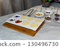 Chocolate and fruit desserts on marble surface with decorative bowls 130496730