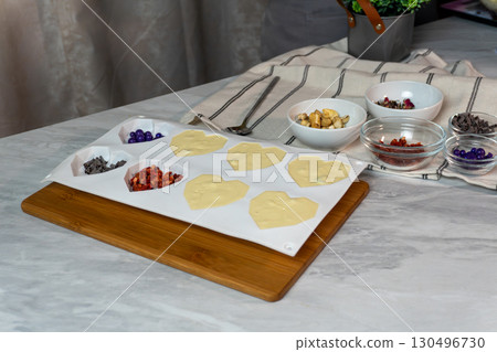 Chocolate and fruit desserts on marble surface with decorative bowls 130496730