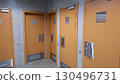 Orange restroom doors with accessibility signs in modern public facility 130496731