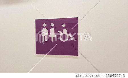 Inclusivity sign with male, female, and wheelchair symbols on purple background 130496743