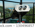 Tourist binoculars overlooking the cityscape. Travel, exploration, and urban sightseeing experience. 130496857