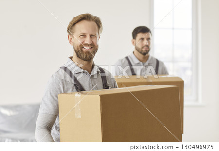 Men delivery workers holding carton boxes with belongings, working in moving company 130496975