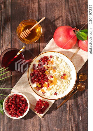 Healthy breakfast with ingredients. Soft grainy cottage cheese with pomegranate seeds, raisins, honey and juice on sunny table, natural food concept, healthy lifestyle advertisement, baby food, Healthy breakfast with ingredients. Soft grainy cottage cheese with pomegranate seeds, raisins, honey and juice on sunny table, natural food concept, healthy lifestyle advertisement, baby food, 130497225