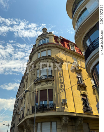 Yellow historic building with red roof and ornate decoration in Belgrade, Serbia. Urban identity, architectural heritage, and European tradition. Yellow historic building with red roof and ornate decoration in Belgrade, Serbia. Urban identity, architectural heritage, and European tradition. 130497253