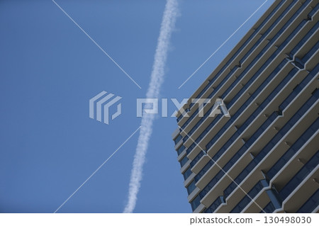 Image of a contrail and an apartment building Image of a contrail and an apartment building 130498030