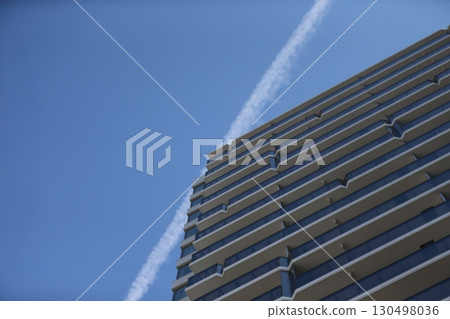 Image of a contrail and an apartment building Image of a contrail and an apartment building 130498036