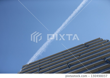 Image of a contrail and an apartment building 130498037
