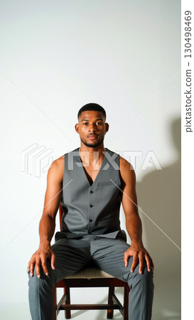Model Poses in Tailored Gray Suit With a Minimalist Backdrop in a Styled Studio Setting 130498469