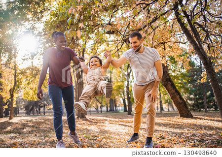 Joyful swing between parents in the park 130498640