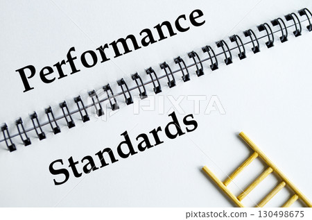 Performance Standards, Notebook with ladder illustration representing excellence, benchmarks, and achievement. Performance Standards, Notebook with ladder illustration representing excellence, benchmarks, and achievement. 130498675
