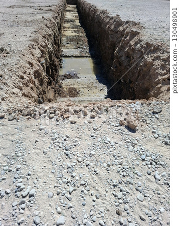 Excavation project in Denia, Spain reveals a trench dug to uncover remnants of an ancient Roman settlement. The site showcases historical importance and archaeological efforts. 130498901