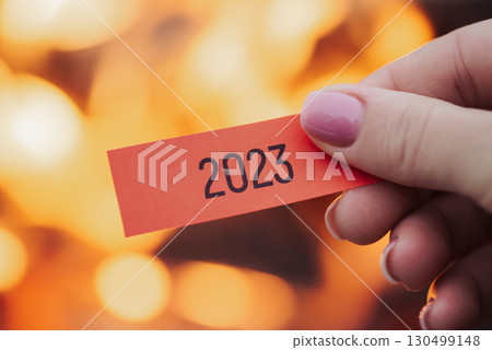 Paper with inscription 2023 in woman's hand with fire on the background. Finally ending up difficult 2023 year and don`t having sympathy to it Paper with inscription 2023 in woman's hand with fire on the background. Finally ending up difficult 2023 year and don`t having sympathy to it 130499148