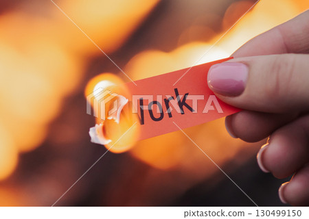 Burning paper in hands of a woman with word work. Concept of losing work, job, difficulties doing duties Burning paper in hands of a woman with word work. Concept of losing work, job, difficulties doing duties 130499150