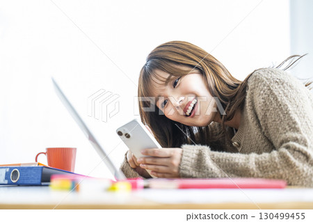 Portrait of a young woman looking at her smartphone 130499455