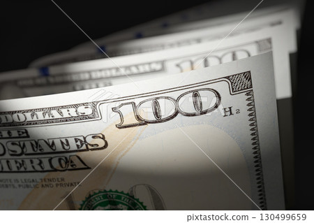 Spot Lit Abstract Close-up Angle of U.S. 100 Dollar Bills Isolated on a Black Background. Spot Lit Abstract Close-up Angle of U.S. 100 Dollar Bills Isolated on a Black Background. 130499659