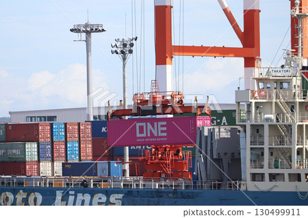 Loading onto a container ship docked at a container terminal Loading onto a container ship docked at a container terminal 130499911