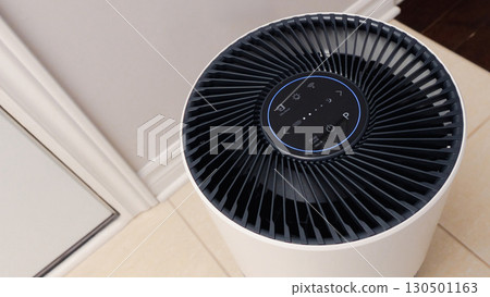 Close up view of Air Purifier with Black Fan. Black Round Electronic Device with Buttons and Bright Lights on White Background 130501163