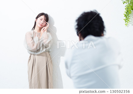 Photographer photographing a model in a studio 130502356