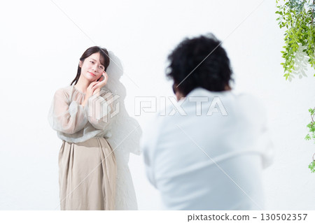 Photographer photographing a model in a studio 130502357