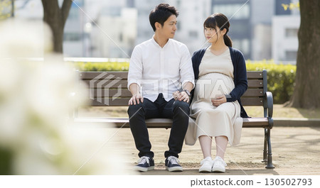 孕婦和丈夫坐在公園的長椅上 孕婦和丈夫坐在公園的長椅上 130502793