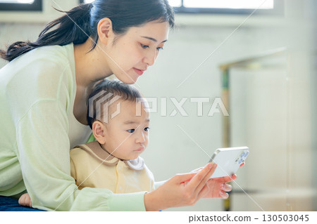 Parent and child seeing smartphone Parent and child seeing smartphone 130503045