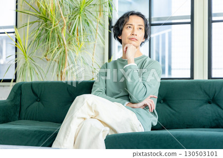 一位中年男子在客廳放鬆 130503101