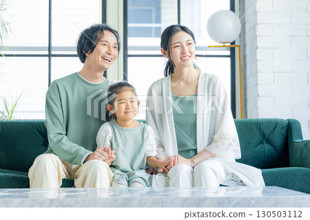 一個在客廳裡放鬆的年輕家庭 130503112