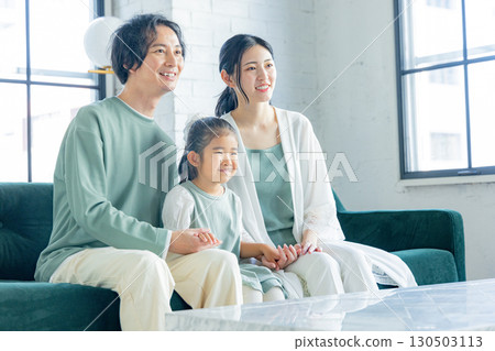 一個在客廳裡放鬆的年輕家庭 130503113