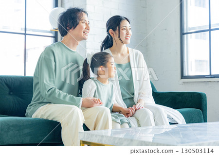 一個在客廳裡放鬆的年輕家庭 130503114