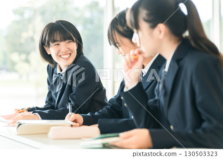 Smiling classmates talking during class, elementary school, junior high school, and high school girls 130503323