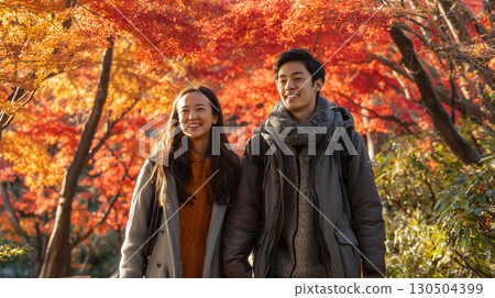 A couple enjoying a date with autumn leaves 130504399