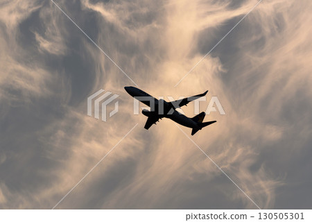 Airplane flying in the sunset, autumn clouds, flight 737 130505301