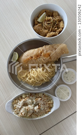 Delicious crispy fish fillet and pasta in a bowl and pan with mozzarella  130506242
