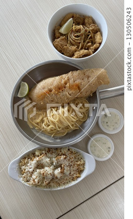 Delicious crispy fish fillet and pasta in a bowl and pan with mozzarella  130506243