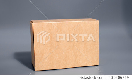 Simple brown cardboard box against gray background Simple brown cardboard box against gray background 130506769