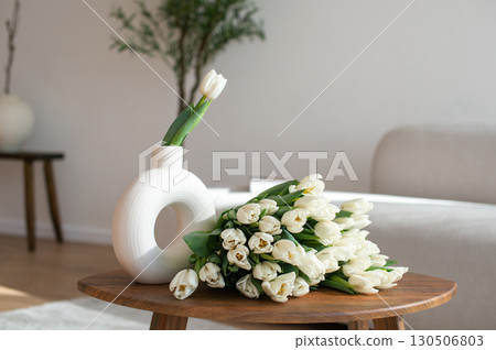 Elegant White Tulips in Modern Vase on Wooden Table 130506803