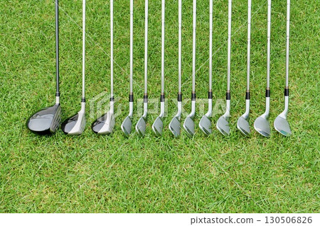 Golf clubs placed on the grass: 3 fairway woods and 10 irons 130506826