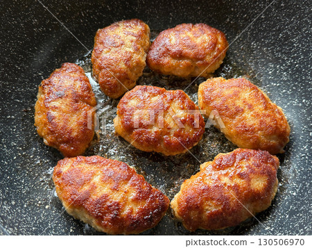 Fried cutlets in a frying pan 130506970