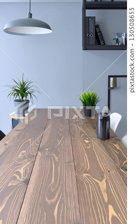 Modern Interior with Dark Wooden Table Plants and Shelf Against Gray Wall Background 130508655