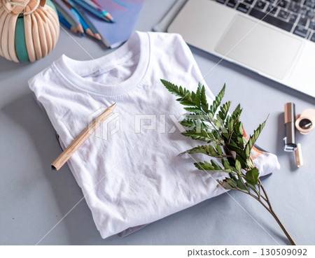 White Tshirt Mockup with Laptop and Green Leaves Flat Lay Top View 130509092