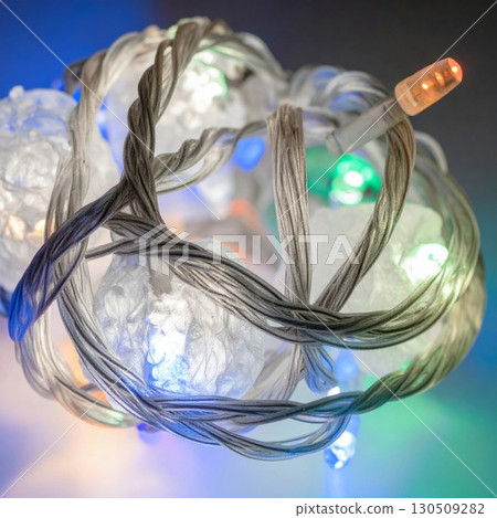 Tangled String of White Holiday Lights with Silver Wire on White Surface 130509282