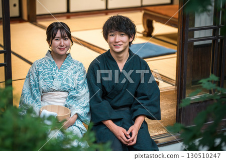 身著浴衣的情侶在溫泉旅館、寺廟住宿或傳統日式房屋的陽台上享受涼爽的晚風 身著浴衣的情侶在溫泉旅館、寺廟住宿或傳統日式房屋的陽台上享受涼爽的晚風 130510247
