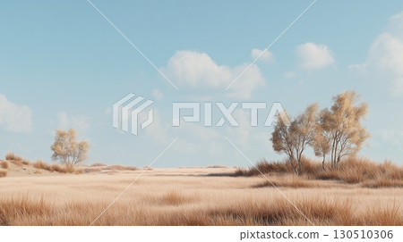 Golden dry grass covers the wide field with scattered trees standing beneath a blue sky 130510306