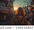 A Korean woman walks a city street her hair glowing in the setting sun 130510407
