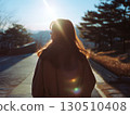 A Korean woman stands on a path her hair beautifully backlit by the brilliant sun 130510408