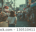 A Korean woman stands and looks into the busy street market filled with shoppers 130510411