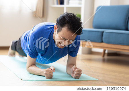 Middle-aged man training at home Middle-aged man training at home 130510974