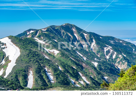 View of Mt. Betsuyama and Obyobu from the snowfields of the Tombitaiwa course. Climbing Mt. Hakusan Gozenmine in early summer. 130511372